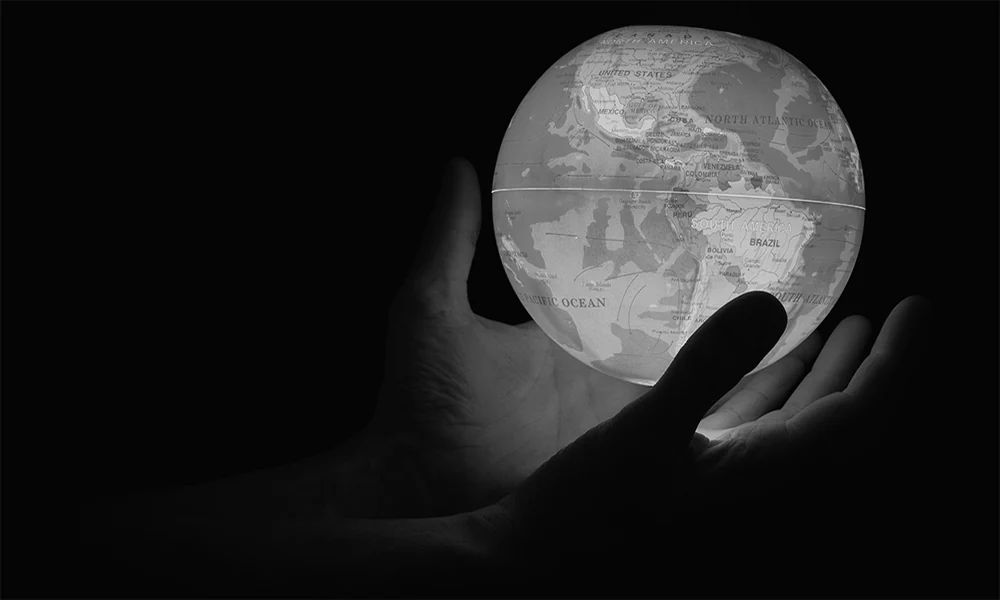 عکس سیاه و سفید دو دست که کره زمین را درون خود نگه داشته اند - موفیت پروژه های سئو بین المللی
